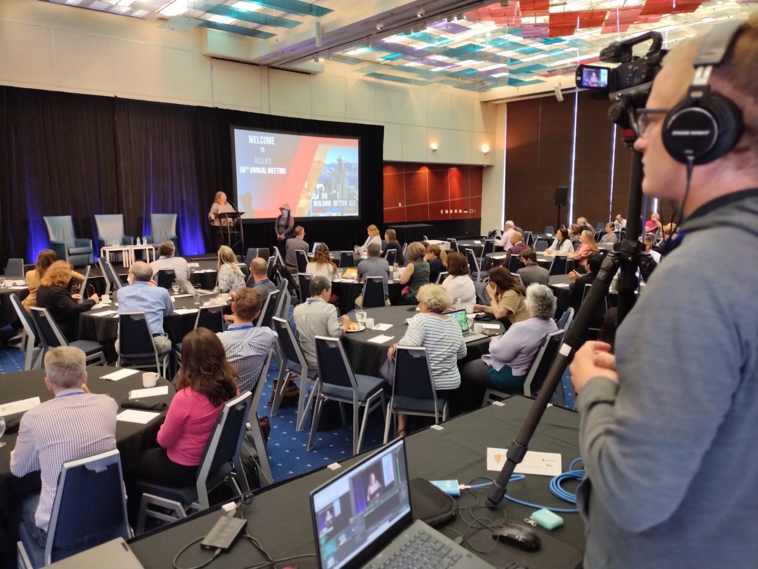 Man with video camera filming in-person conference event