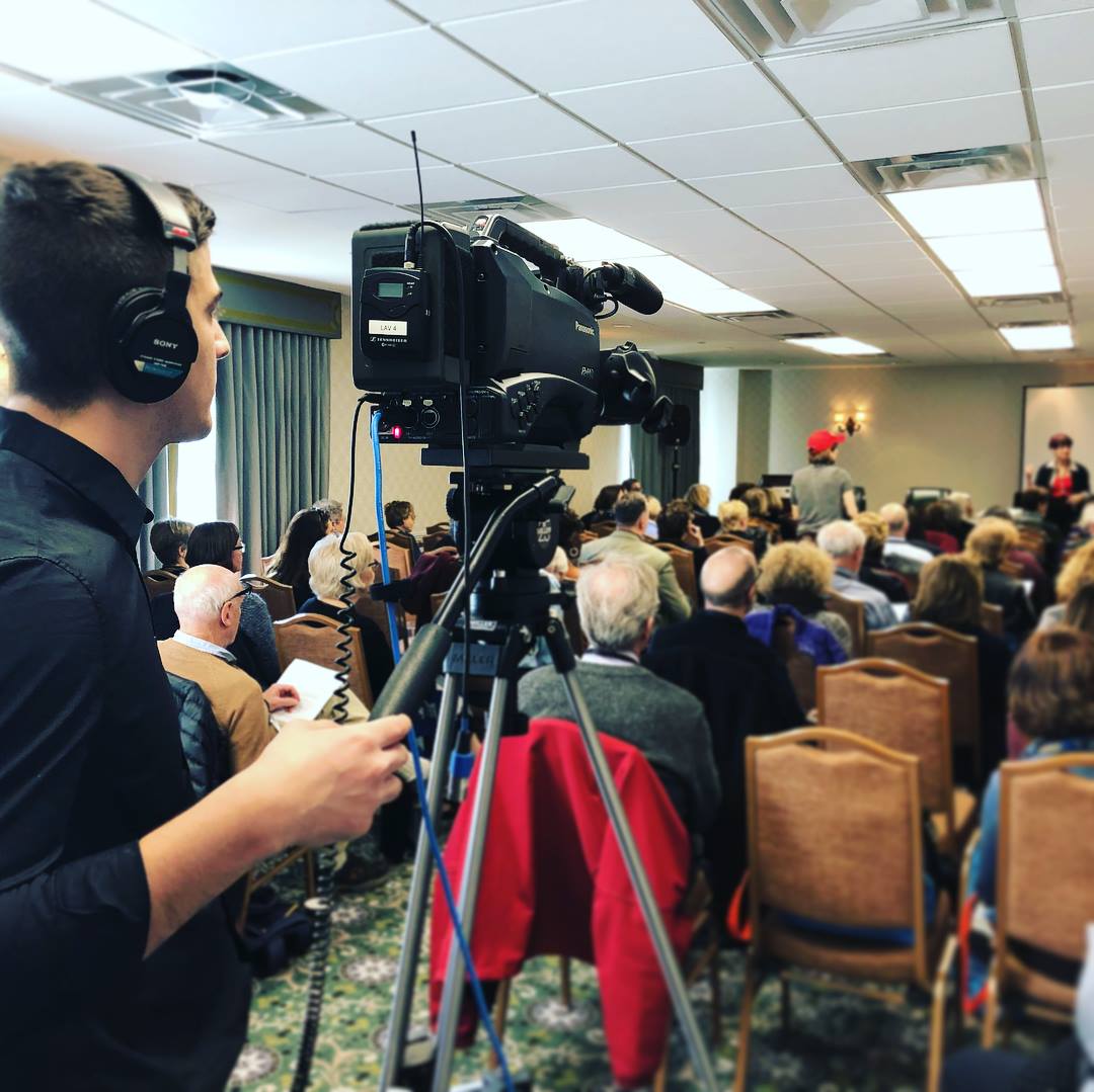 A professional videographer filming a live legal seminar, representing CE21’s expert webcasting production services and rock-solid live streaming infrastructure for education directors